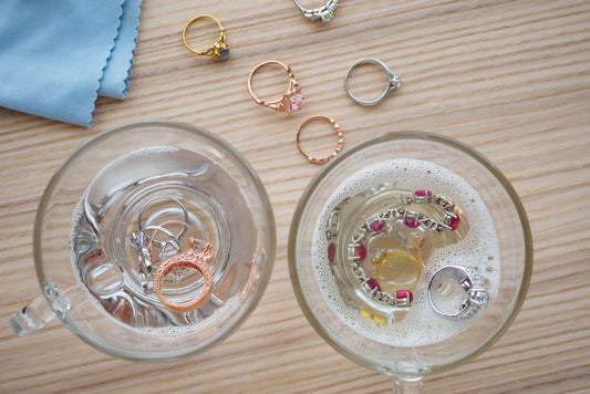 cleaning jewelry diamond ring with glass of hot water and dishwashing liquid on wood table background - Mia Ishaaq