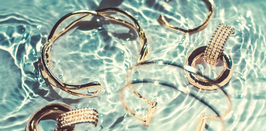 Gold jewellery pieces in a water - Mia Ishaaq