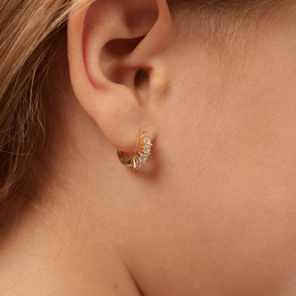 Side view of a child model wearing the 925 sterling silver, 14k gold-plated earrings, focusing on the ear and earring design - Mia Ishaaq