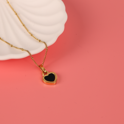 Gold water-resistant reversible enamel heart pendant beaded chain necklace placed over a white ceramic bowl on a pink background - Mia Ishaaq