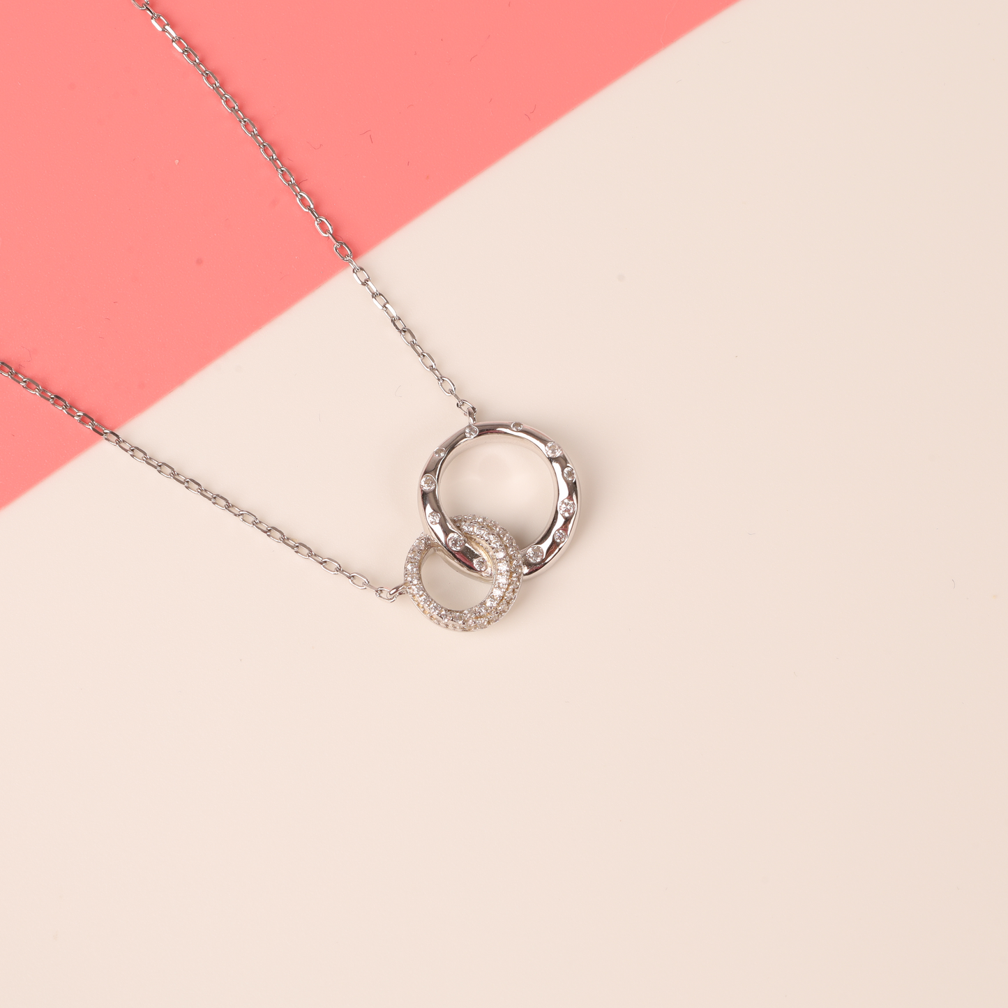 Detail side view of the 925 sterling silver interlocking circle eternity friendship necklace on a plain white background on a white background - Mia Ishaaq