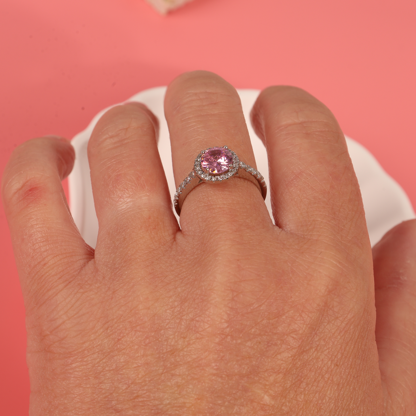 Close-up shot of the ring on a model's hand, emphasising the pink centrepiece and the clear cubic zirconia halo - Mia Ishaaq