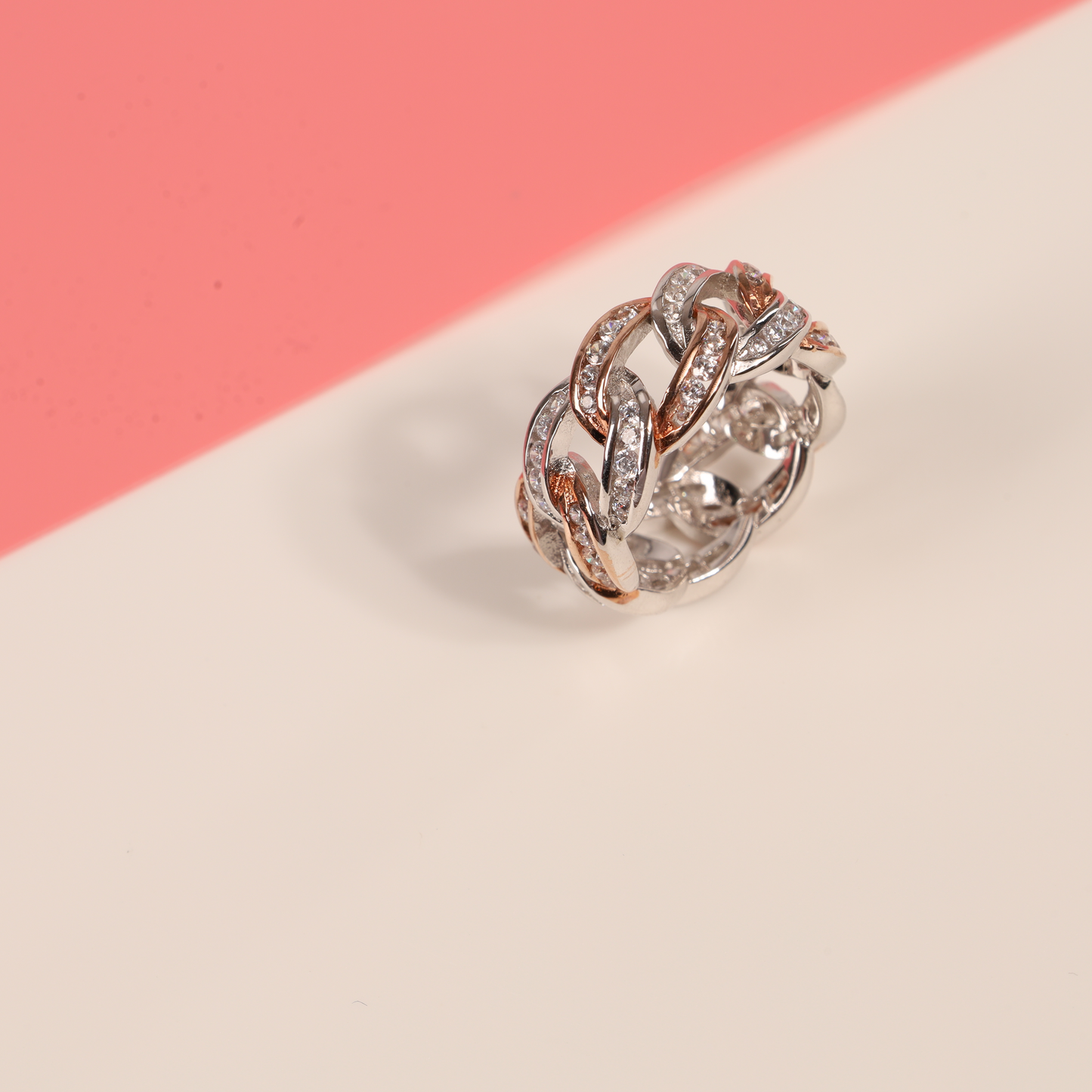 Top view of the rose gold-plated Cuban link ring on a half white, half pink background - Mia Ishaaq