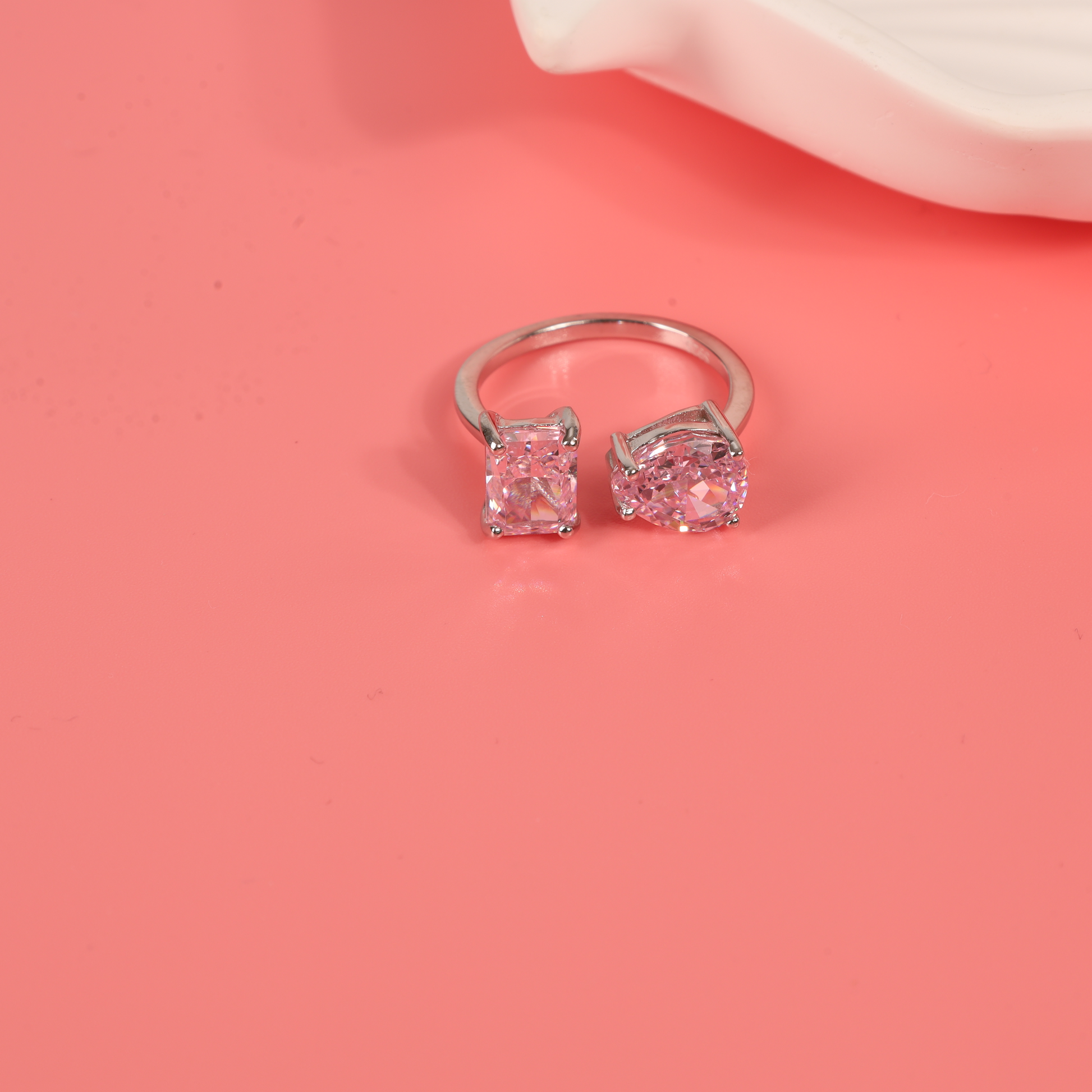 Sterling silver open ring with pink cubic zirconia on a pink background - Mia Ishaaq