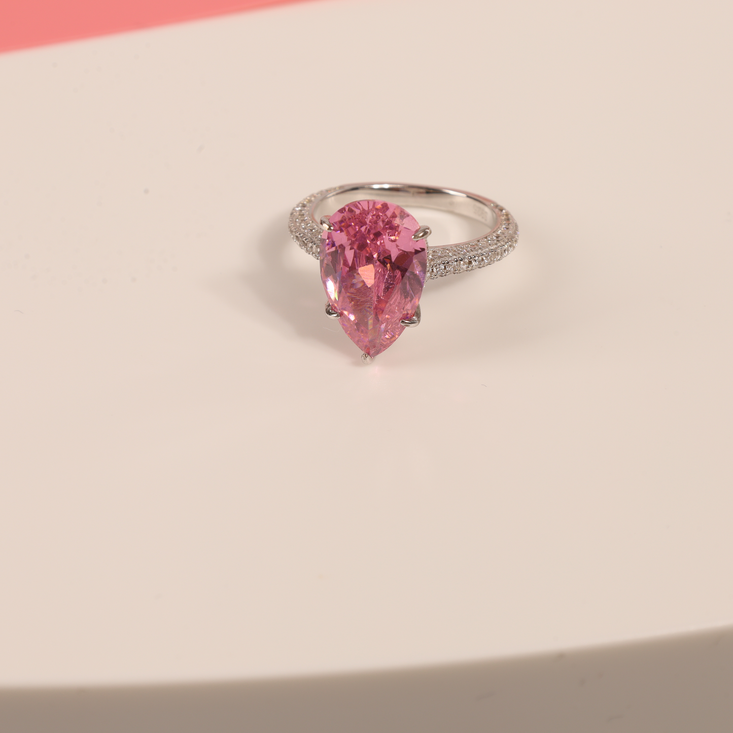 Close-up of the Blush Drop Elegance Ring on a pink background, with white props creating a dreamy and elegant atmosphere - Mia Ishaaq