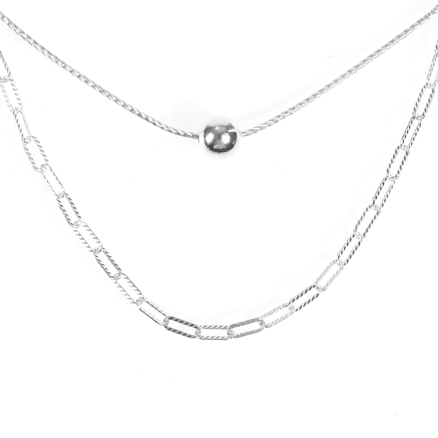 Close-up of the layered sterling silver necklace on a plain white background, highlighting the ball pendant and link chain design - Mia Ishaaq