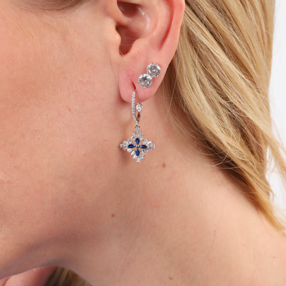 A close-up showcases a woman's ear adorned with Mia Ishaaq's stunning Blue Spinel CZ Earrings in a star-shaped design, crafted from 925 sterling silver and paired with an elegant Cubic Zirconia stud above.