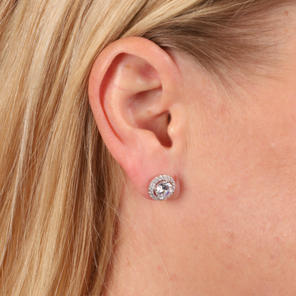 Close-up of a woman's ear adorned with Halo Radiance Sparkling Stud Earrings by Mia Ishaaq.