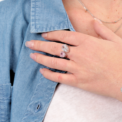 A person sporting a denim shirt displays the Mia Ishaaq Sterling Silver Radiant Duo Ring, adjustable, highlighting its modern sleek design with two prominent gemstones on their hand.