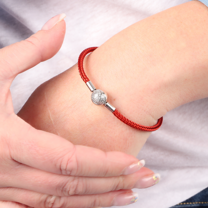 The ATHENAIE Heart of Fire Braided Charm Bracelet elegantly adorns the wrist with its red wire, CZ love heart clasp, and 925 sterling silver accents.