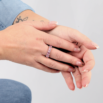 Hands adorned with tattoos are elegantly complemented by the Mia Ishaaq Sterling Silver Pink Wide Band Ring, which features a pink simulant stone that rests gently on one finger.