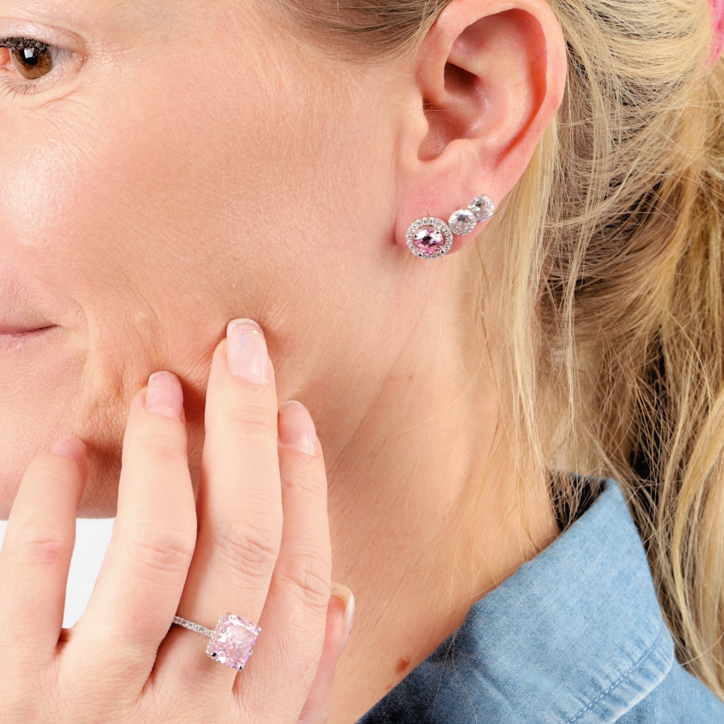 Close-up of a person showcasing the Mia Ishaaq 925 Sterling Silver PINK CZ Stud Earrings paired with a matching pink ring, elegantly designed with sparkling cubic zirconia.