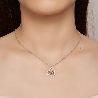 Front view of a model wearing Sterling Silver Cubic Zirconia Mothers Love Heart Pendant with baby footprints necklace - Mia Ishaaq